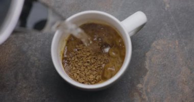 Kaynayan su, hazır kahve, yavaş çekim ve makro manzaralı bir bardağa doldurulur. 300fps, Blackmagic Ursa Pro G2. 