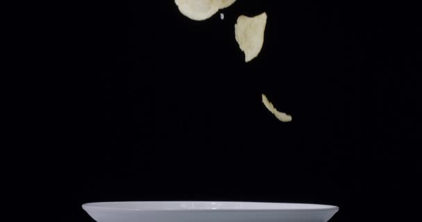 天然薯片落在黑色背景的白盘上 慢动作300 Fps黑魔法Ursa Pro — 图库视频影像