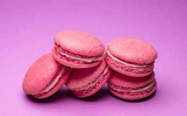 Renkli, tatlı badem kurabiyeleri, mor arkaplanda aromalı kurabiyeler..