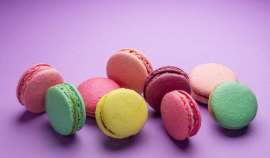 Renkli, tatlı badem kurabiyeleri, mor arkaplanda aromalı kurabiyeler..