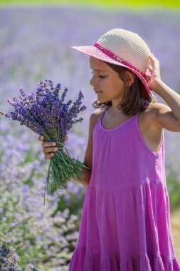 Lavanta tarlasında elinde lavanta demeti olan küçük bir kızın portresi..