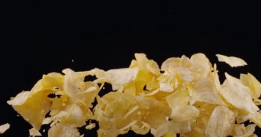 Doğal patates cipsi siyah arka planda yükselip alçalır. Yavaş Hareket 300 fps Blackmagic Ursa Pro G2.
