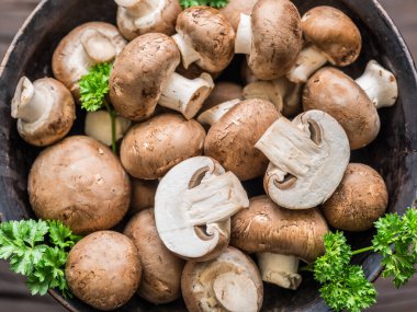 Kahverengi, yenilebilir mantarlar ya da ahşap masada otlarla birlikte kremini mantarlar. Üst görünüm.