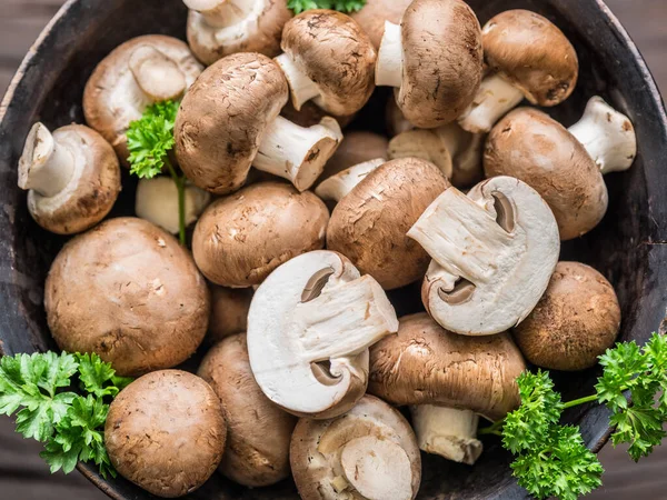 Kahverengi, yenilebilir mantarlar ya da ahşap masada otlarla birlikte kremini mantarlar. Üst görünüm.