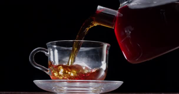 Tea Slowly Poured Glass Cup Teapot Black Background — Stock Video