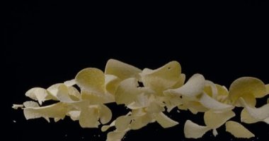 Doğal patates cipsi siyah arka planda yükselip alçalır. Yavaş Hareket 300 fps Blackmagic Ursa Pro G2.