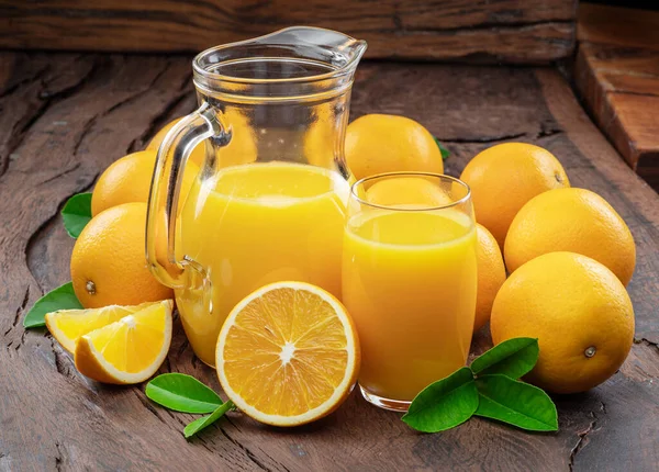 Gelbe Orangenfrüchte Und Frischer Orangensaft Isoliert Auf Dunklem Holzgrund — Stockfoto