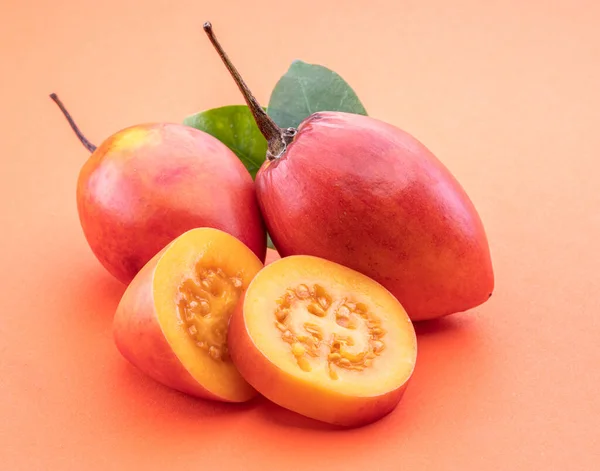 Ripe Tamarillo Fruits Slices Tamarillo Leaves Isolated Orange Background — Stock Photo, Image