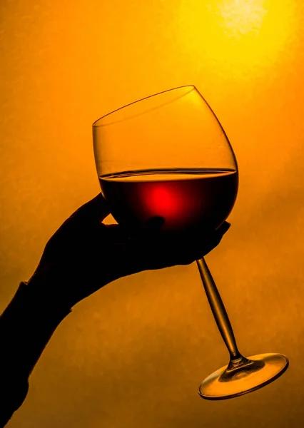 日没時に赤ワインを飲む 赤ワインのグラスを持っている女性の手 — ストック写真