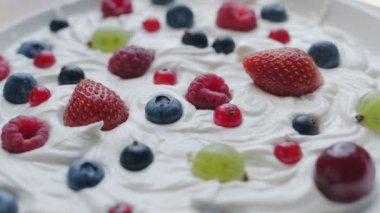 Yaz meyveleri yumuşak süt yoğurdunun yüzeyindedir, yavaş çekimde, makro çekimde..