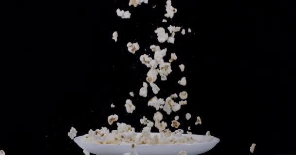 Fiocchi Popcorn Cadono Lentamente Piatto Bianco Uno Sfondo Nero Blackmagic — Video Stock