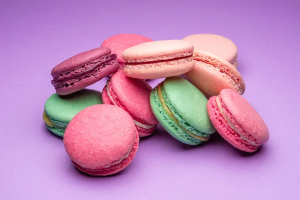 Renkli, tatlı badem kurabiyeleri, mor arkaplanda aromalı kurabiyeler..