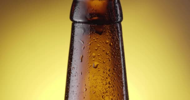 Bierdruppel Druppelt Langzaam Door Beslagen Bierfles Camera Volgend Gele Achtergrond — Stockvideo