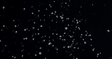 Siyah bir zemine düşen su damlaları yavaşça düşer. Blackmagic Ursa Pro G2, 300 fps.