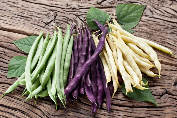 Frijoles verdes frescos en la vieja mesa de madera . — Foto de Stock