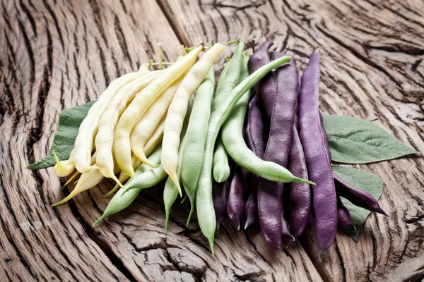 Frijoles verdes frescos en la vieja mesa de madera . — Foto de Stock