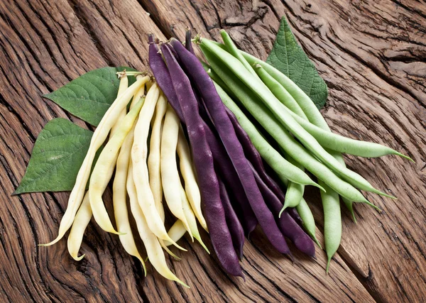 Frijoles verdes frescos en la vieja mesa de madera . — Foto de Stock