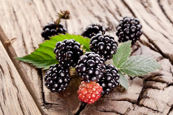 Blackberries with leaves on a old wooden table. — Stock Photo, Image
