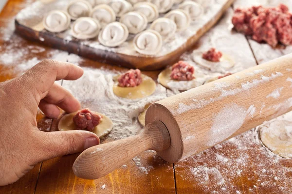 Dumplings. Dough with meat filling on the cook's hands. — Stock Photo, Image