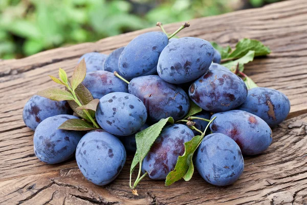 Plums on an old wooden table. — Stock Photo, Image