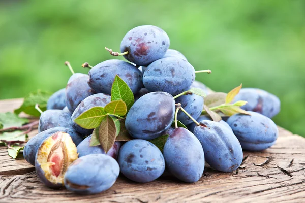 Plums on an old wooden table. — Stock Photo, Image