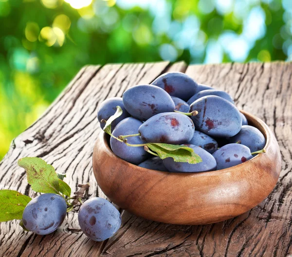 Plums on an old wooden table. — Stock Photo, Image