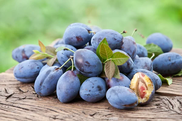 Pruimen op een oude houten tafel. — Stockfoto