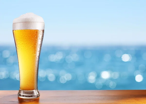 Cold beer glass on the bar table at the open-air cafe. Stock Picture