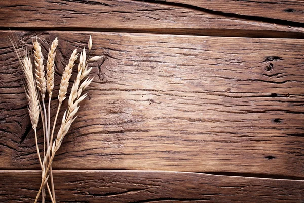 Oreilles de blé sur une vieille table en bois . — Photo