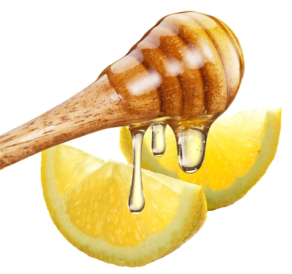 Honey with wood stick pouring onto a slice of lemon. — Stock Photo, Image