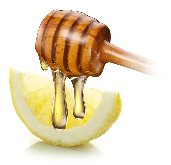 Honey with wood stick pouring onto a slice of lemon. — Stock Photo, Image