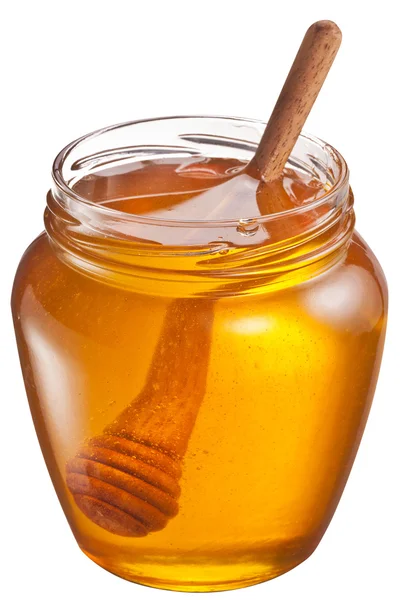 Lata de vidrio llena de miel y palo de madera en ella. Recorte de caminos . — Foto de Stock
