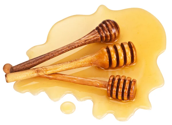 Wooden sticks lays in honey stain. — Stock Photo, Image