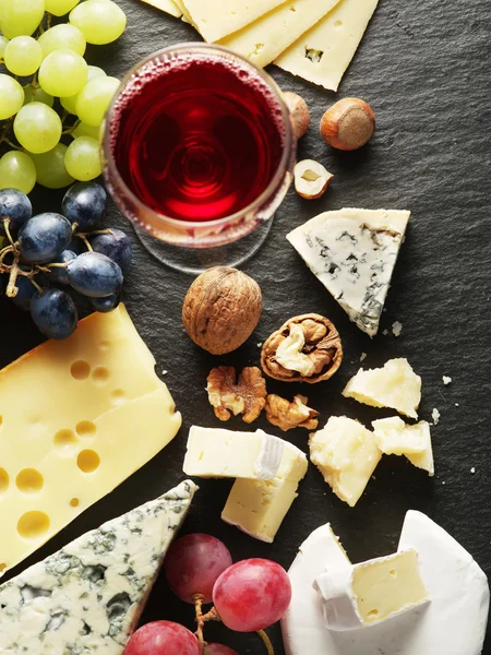 Diversi tipi di formaggi con bicchiere di vino e frutta . — Foto Stock