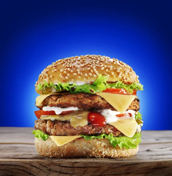 Hamburger na starý dřevěný stůl. — Stock fotografie