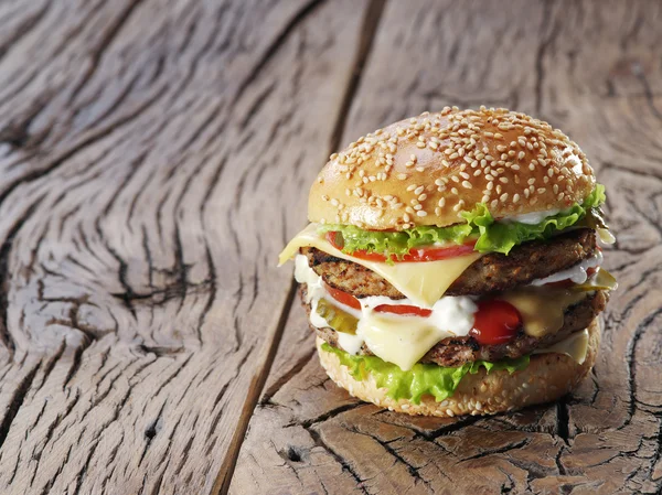 Hamburger on old wooden table. — Stock Photo, Image