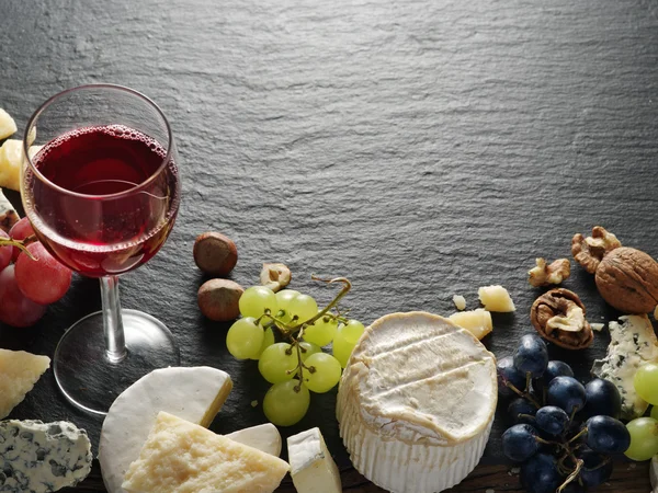 Diferentes tipos de quesos con copa de vino y frutas . — Foto de Stock