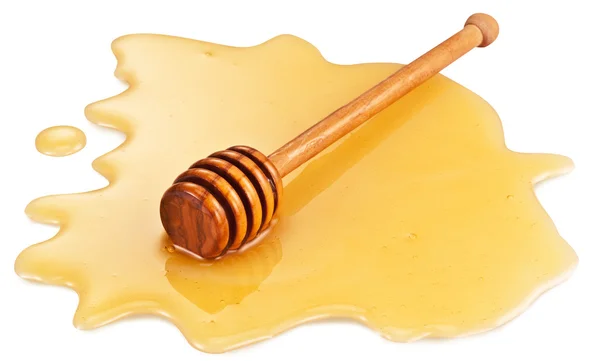 Dřevěná hůl v louži medu. Ořezové cesty. — Stock fotografie