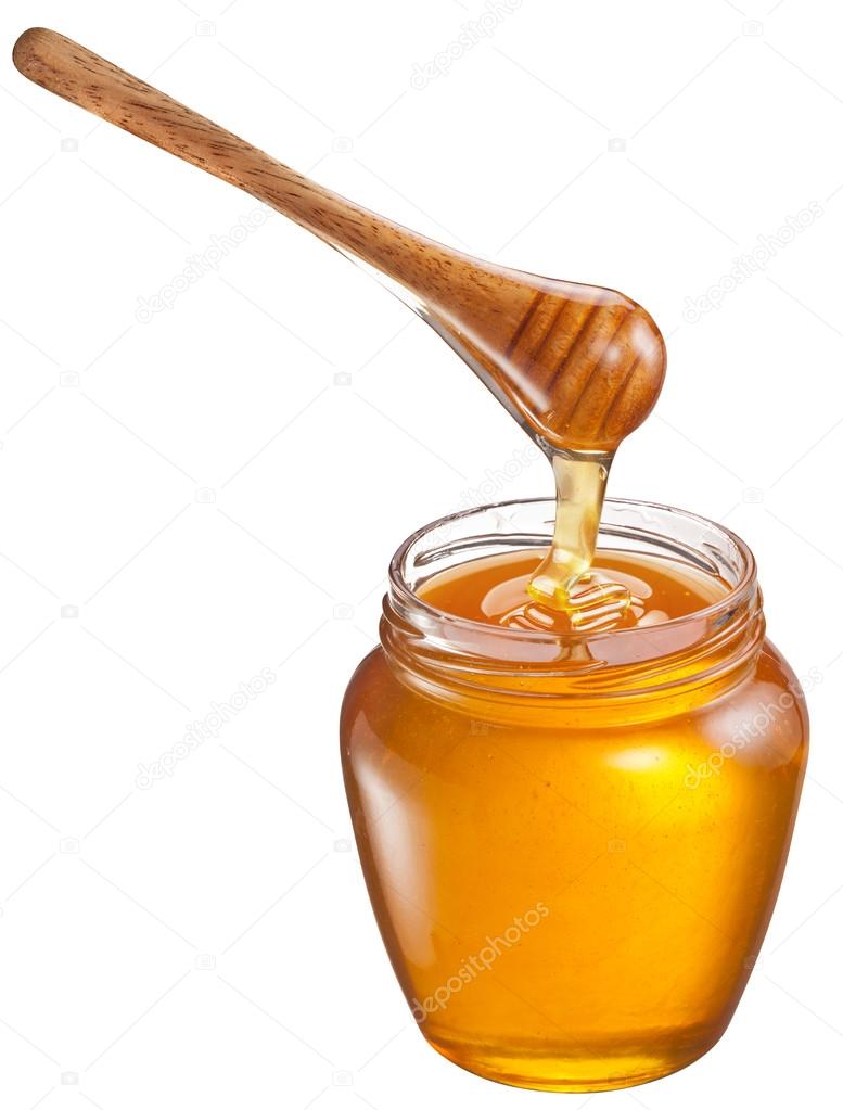 Honey flowing into glass jar. File contains clipping paths. 