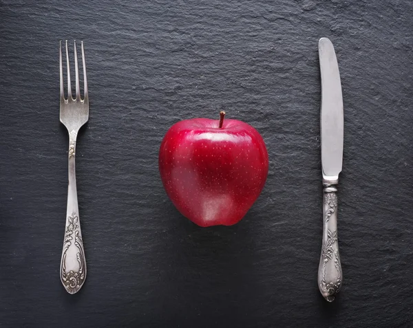 Ajustes rojos de manzana y mesa sobre un fondo gris oscuro . —  Fotos de Stock