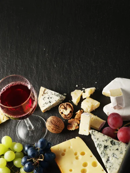 Διαφορετικούς τύπους τυριών με ποτήρι κρασί και φρούτα. — Φωτογραφία Αρχείου