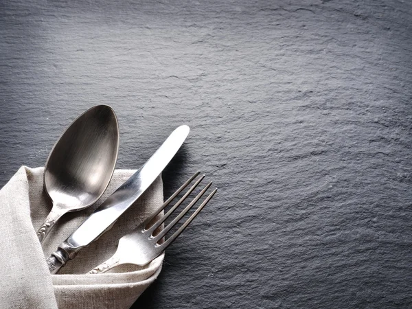 Silver cutlery on a dark grey background. — Stock Photo, Image
