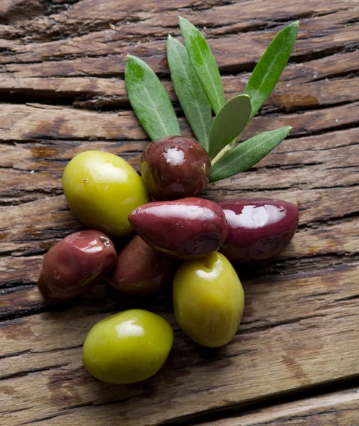 Ramoscello di ulivo e olive su vecchio tavolo di legno . — Foto Stock