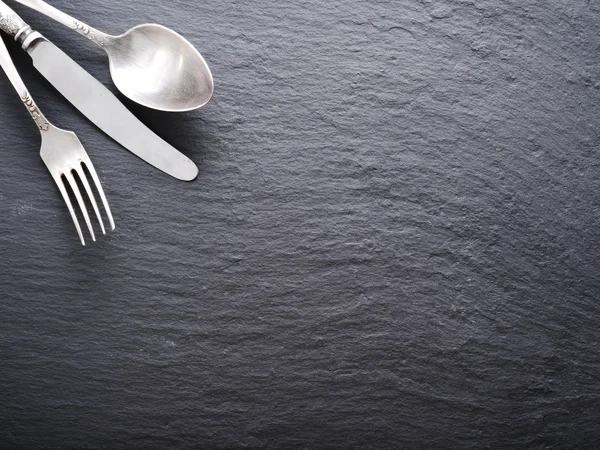 Silver cutlery on a dark grey background. — Stock Photo, Image