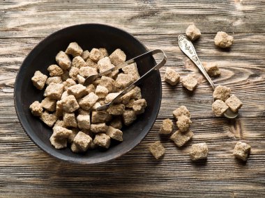 Ahşap masa üzerinde kapta şeker kamışı küp.