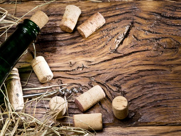 Botella de vino y corchos en una vieja mesa de madera . — Foto de Stock