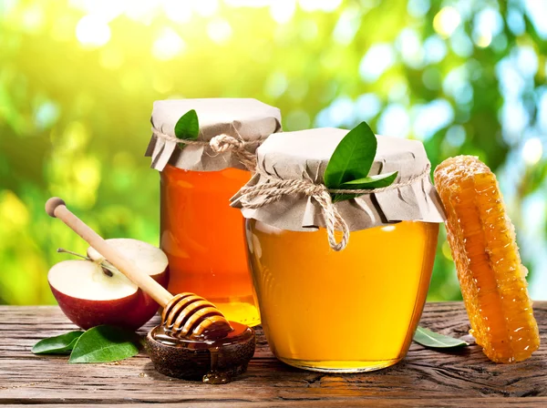 Latas de vidrio llenas de miel, manzanas y panales . —  Fotos de Stock