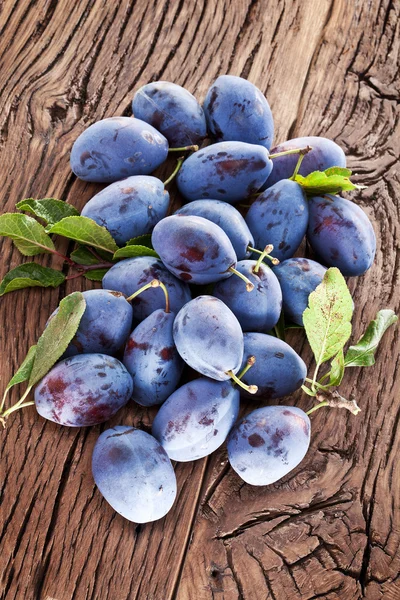 Plums on an old wooden table. — Stock Photo, Image