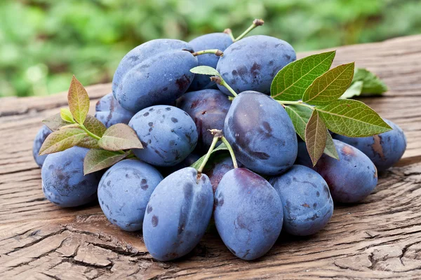 Plums on an old wooden table. — Stock Photo, Image