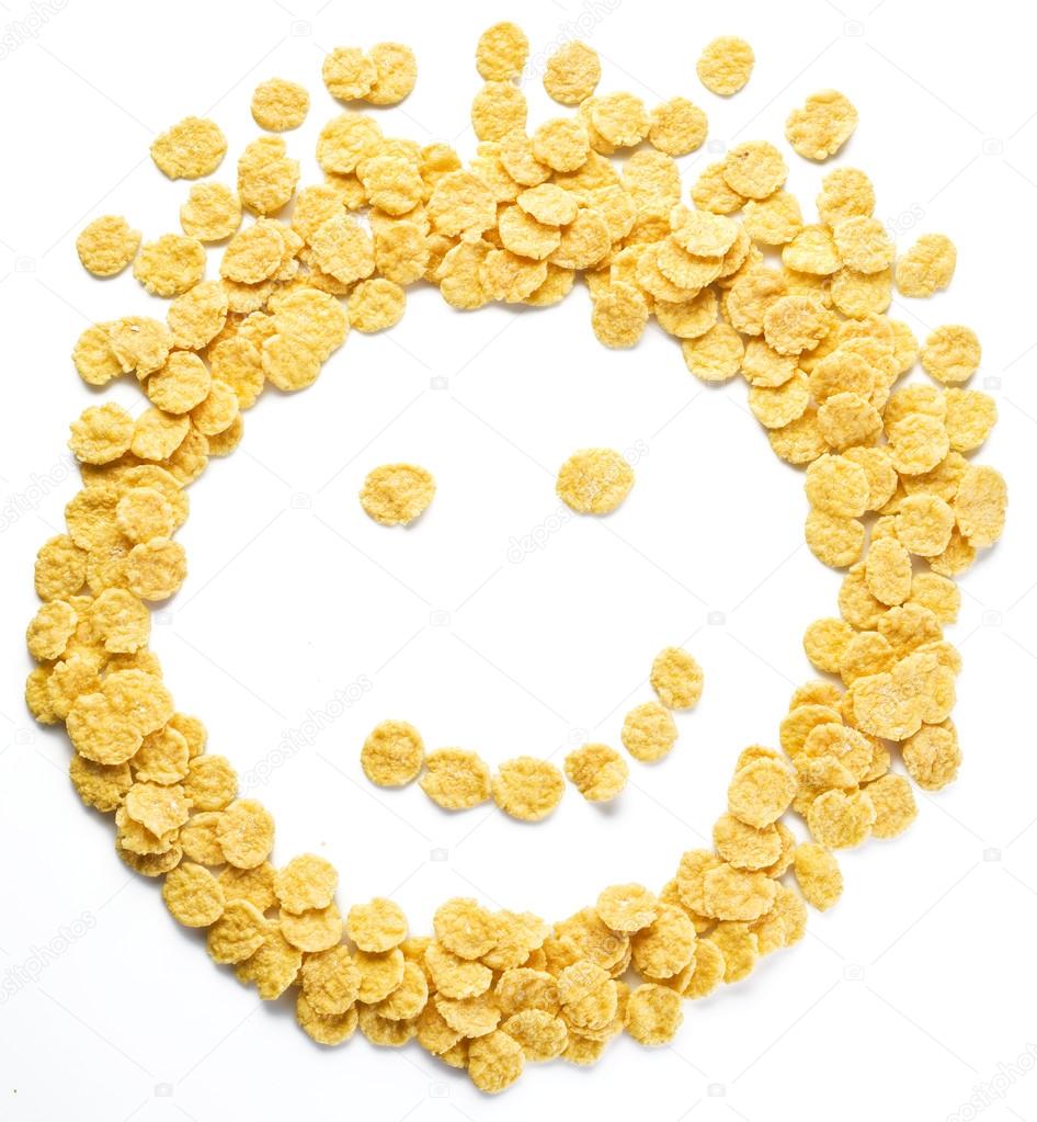 Cornflakes arranged as smiley face on a white background. 